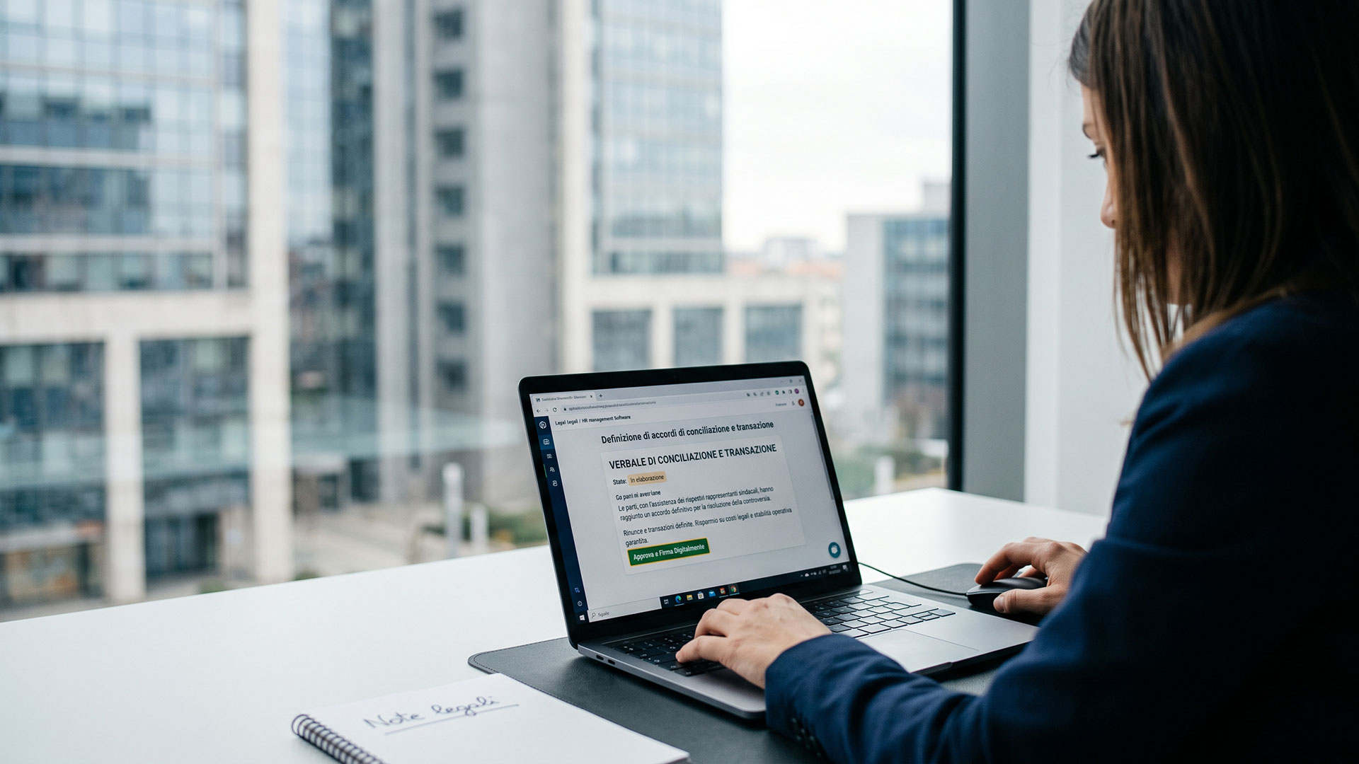 Stesura al laptop di un verbale di conciliazione e transazione per la risoluzione stragiudiziale di controversie.