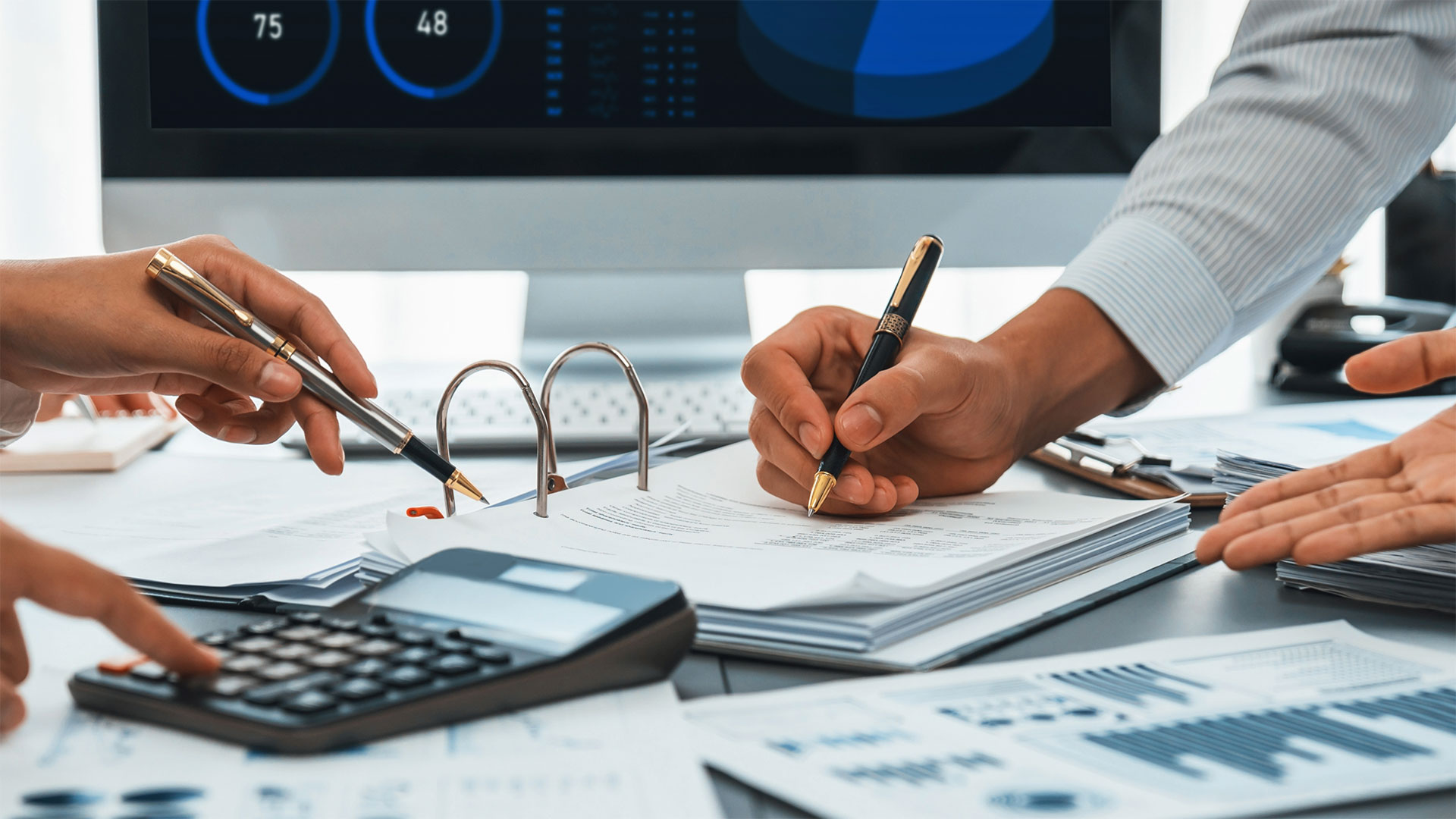 Team di professionisti analizza documenti contabili e grafici finanziari durante una consulenza fiscale in ufficio