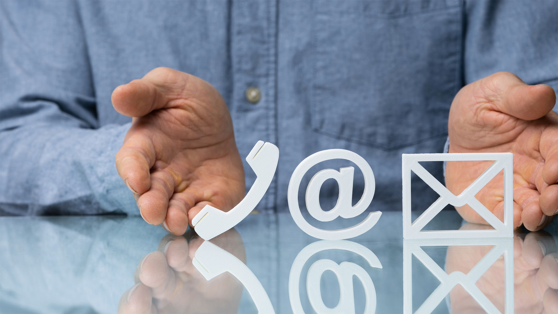 Mani di un professionista che presentano icone 3D di telefono, email e posta, simbolo di assistenza e contatti